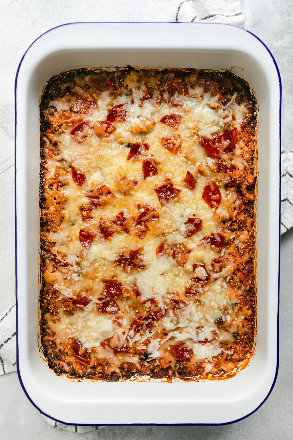 Overhead view baking dish filled with pepperoni pizza quinoa casserole