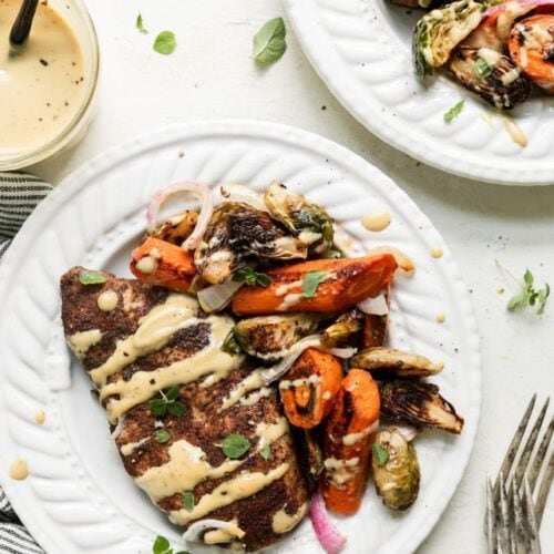 White plate with serving of harvest sheet pan chicken dinner with roasted vegetables.