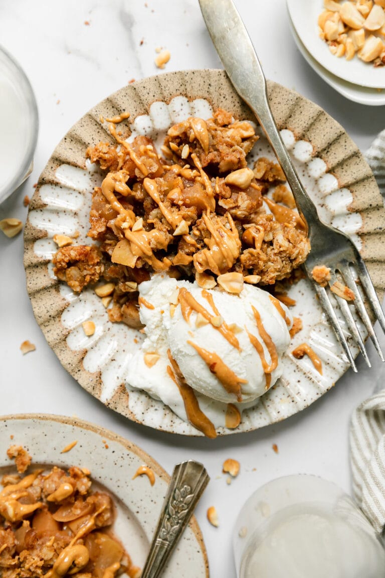 Overhead view of a plate of peanut butter apple crumble with ice cream on the side. 