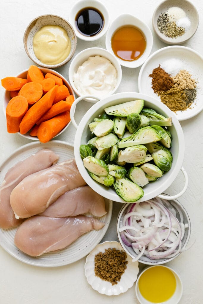 All ingredients for harvest sheet pan chicken and veggies arranged in small bowls