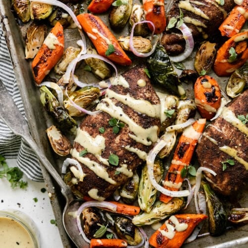 Sheet pan Harvest chicken with roasted veggies, maple dijon dressing drizzled over top.