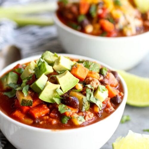 Two white bowls filled with veggie loaded turkey chili.