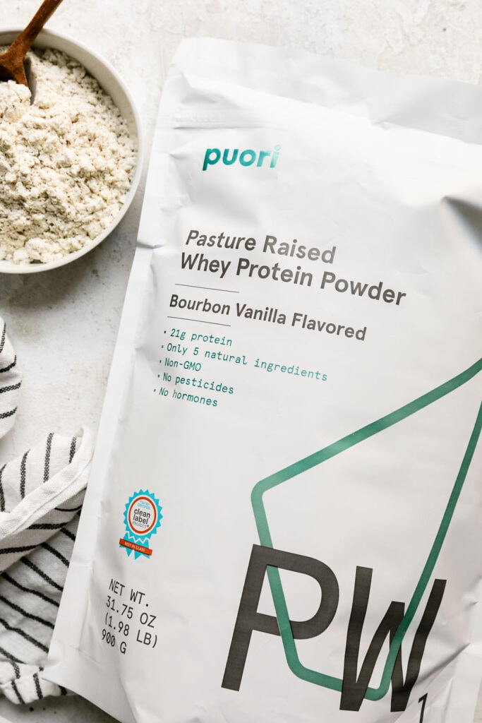 Overhead view of a bag of Puori Protein powder and a dish filled protein powder beside it. 
