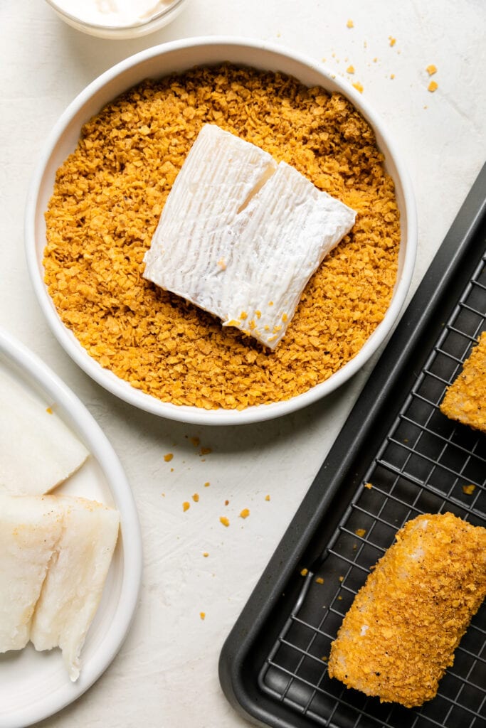 Process shot of cod fillet in chip crumbs coating both sides. 