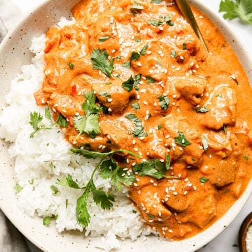 a bowl of crockpot Indian butter chicken served over white rice