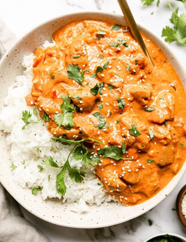 a bowl of crockpot Indian butter chicken served over white rice