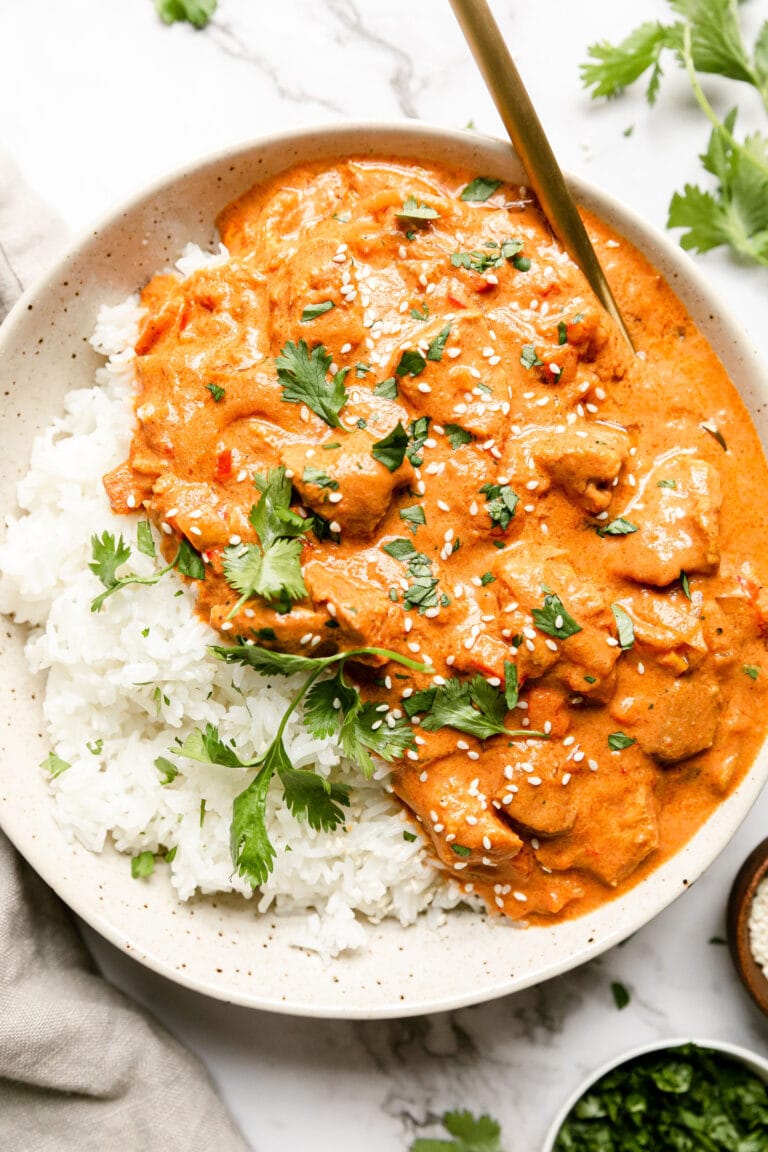a bowl of crockpot Indian butter chicken served over white rice
