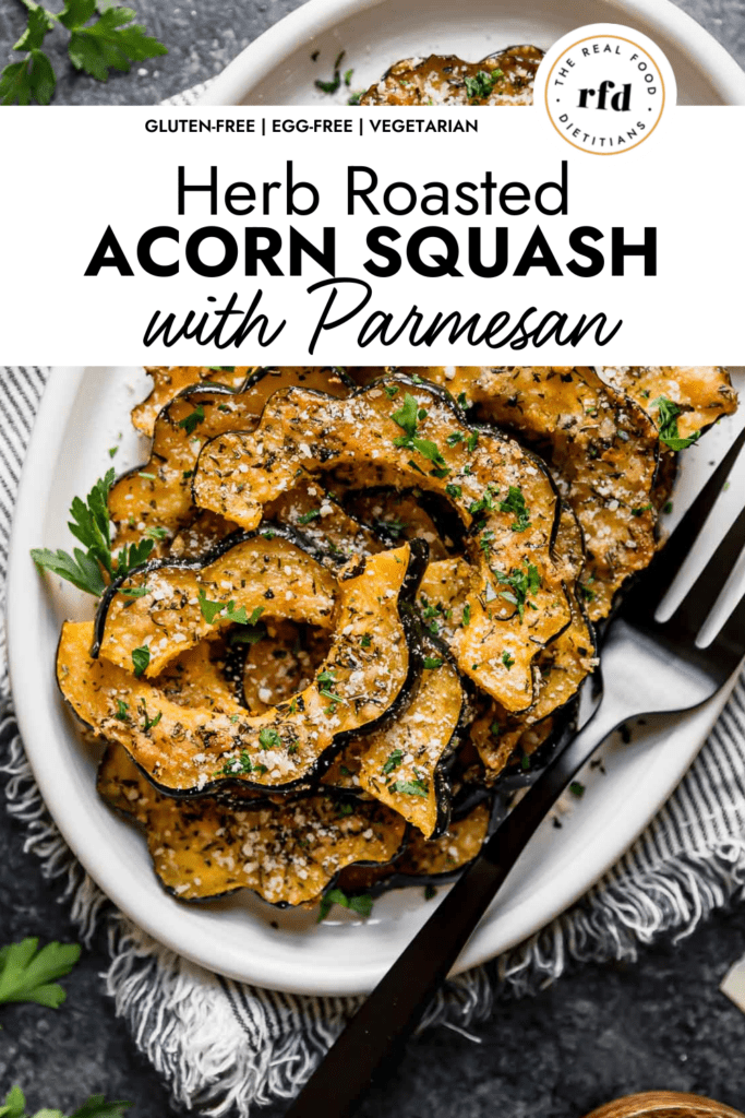 White platter filled with herb roasted acorn squash slices with melted Parmesan cheese.