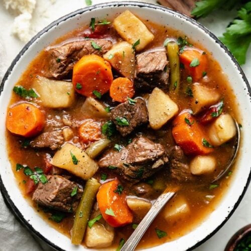 Overhead view rustic bowl filled with slow cooker beef stew with root vegetables