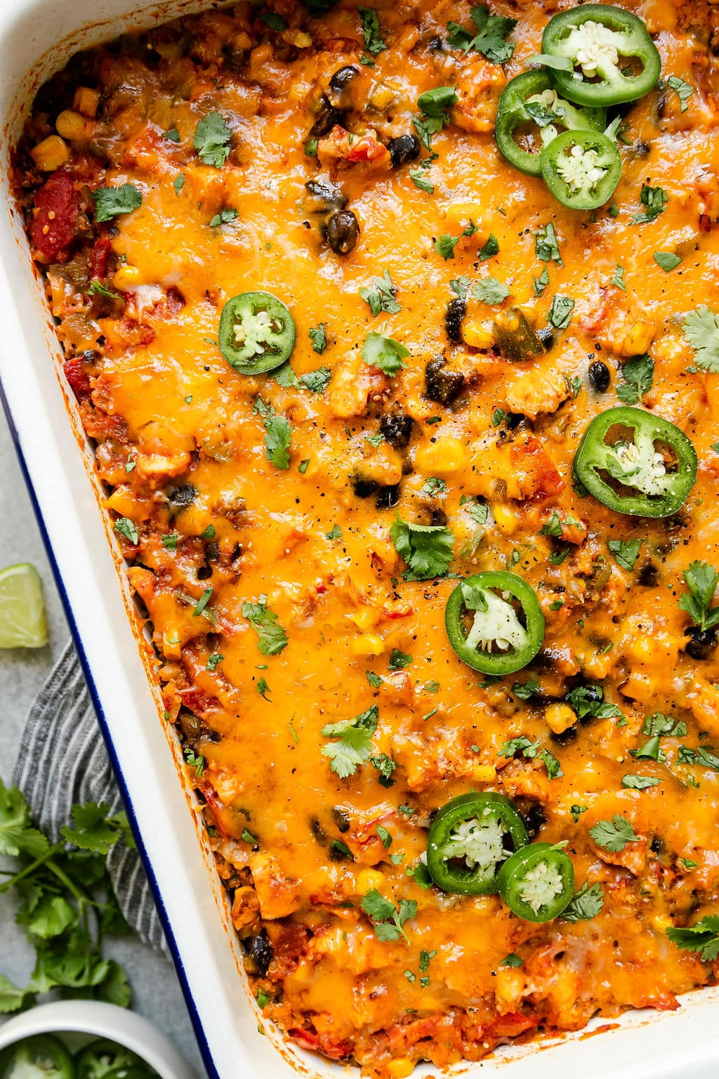 Overhead view Southwest Chicken Quinoa Casserole in baking dish with melted cheddar cheese. 