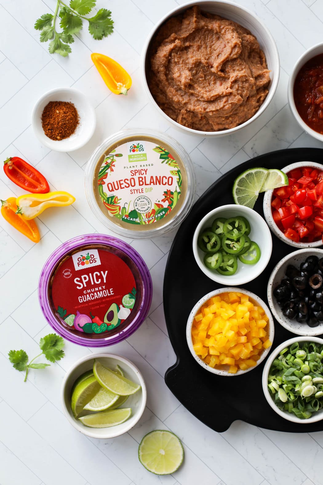 All ingredients for 7 layer dip arranged in bowls and in containers 