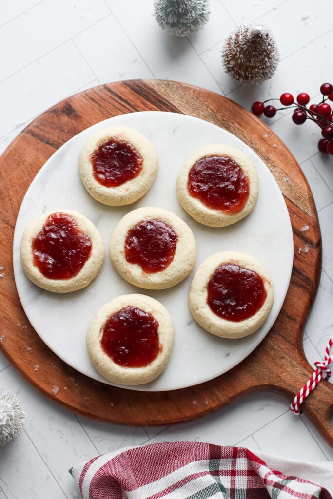 Overhead view raspberry thumbprint cookies on a marble round tray
