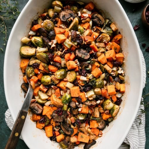 Overhead view white casserole dish filled with sweet potato unstuffing, serving spoon in stuffing.