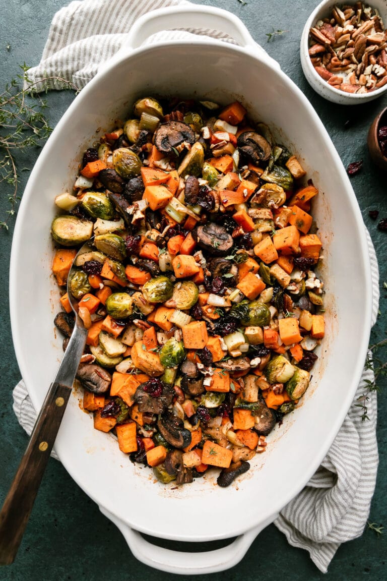 Overhead view white casserole dish filled with sweet potato unstuffing, serving spoon in stuffing.