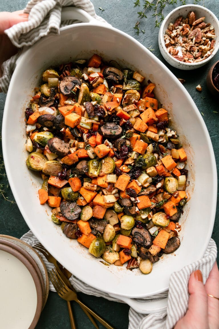 A large oval pan filled with freshly baked sweet potato unstuffing topped with pecan pieces. 