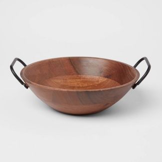 Wooden serving bowl with black handles on white background.