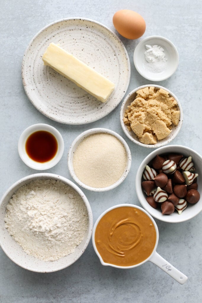 All ingredients for peanut butter blossoms in small bowls arranged together.