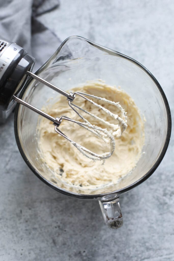 Mixing bowl with pour spout with whipped butter and vanilla for Pecan Snowball Cookies