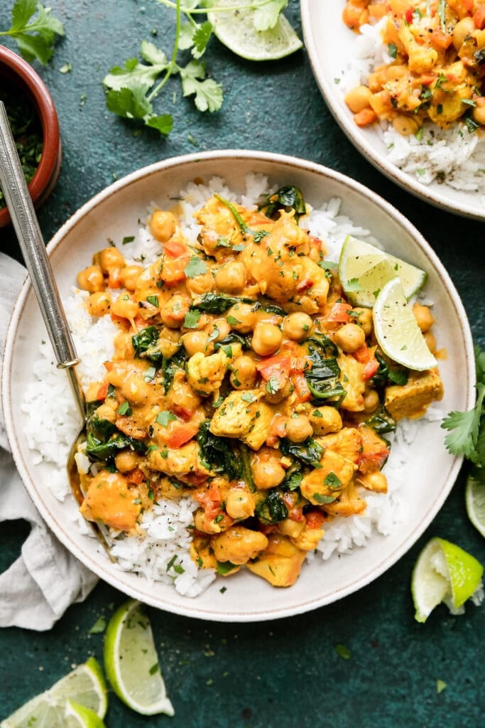 Overhead view stone bowl filled with serving of white rice and chicken and chickpea curry