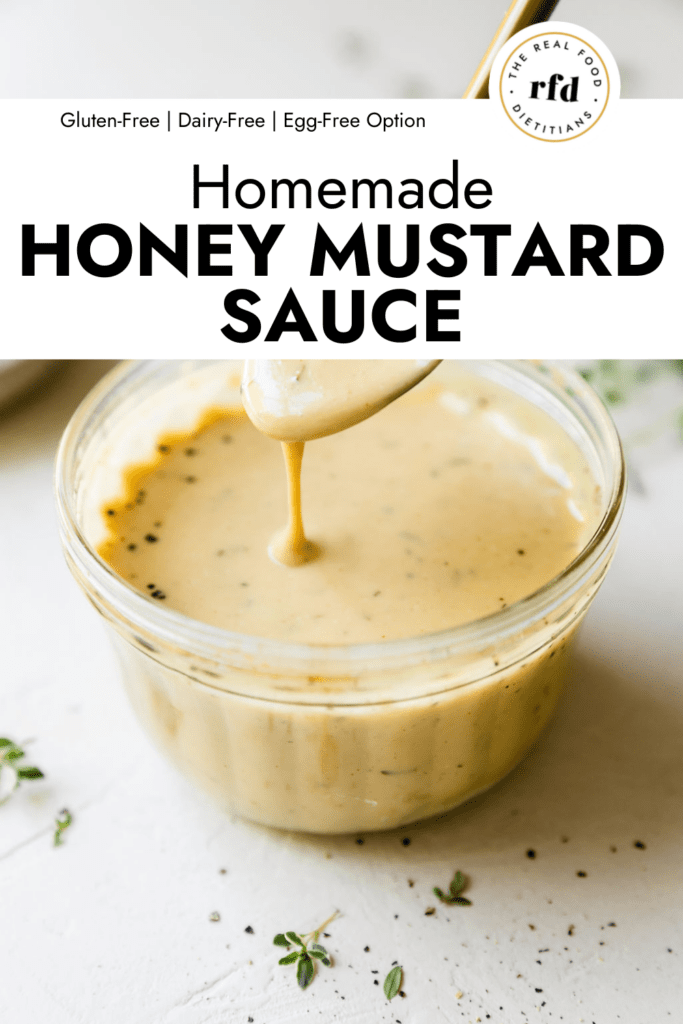 Honey mustard sauce being drizzled off spoon into small jar of honey mustard sauce.