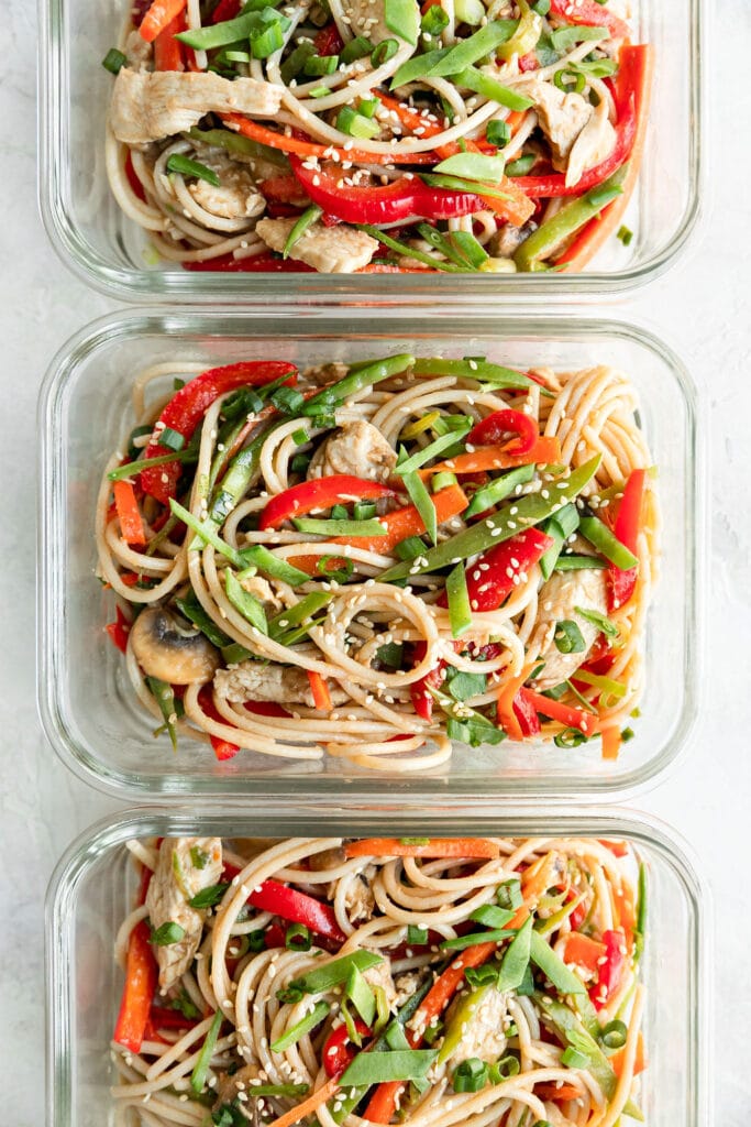 three meal prep containers full of stir fry noodles. 