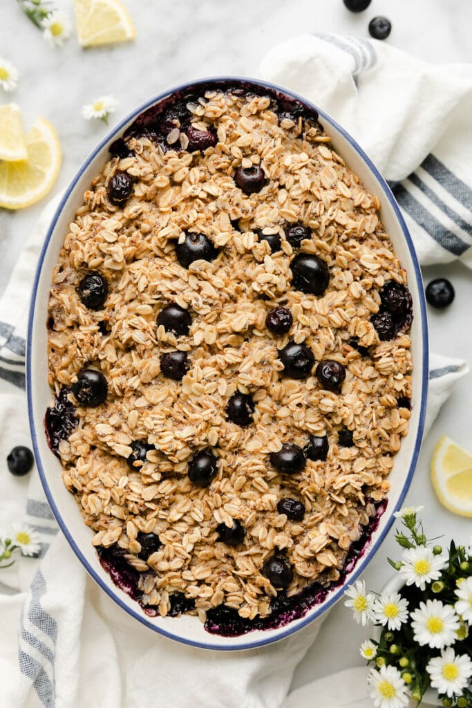 Overhead view oval baking dish filled with blueberry lemon baked oatmeal