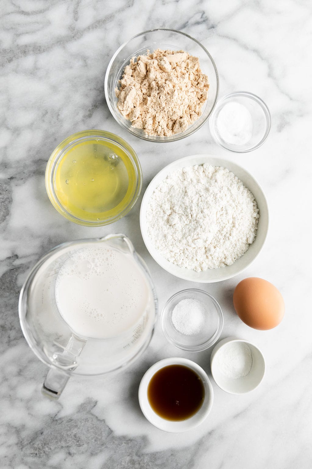 All ingredients for protein pancakes in small bowls.