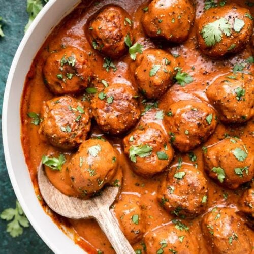 Beef and lentil meatballs in skillet with red sauce.