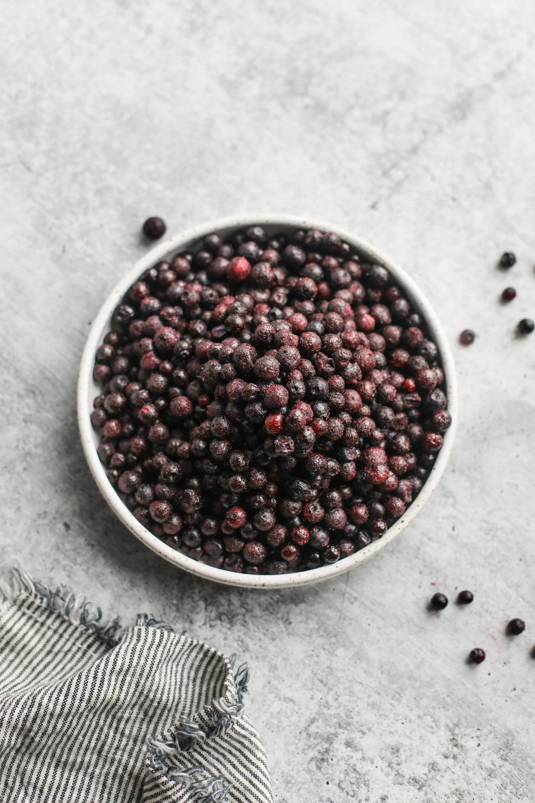 Overhead view shallow bowl filled with frozen wild blueberries