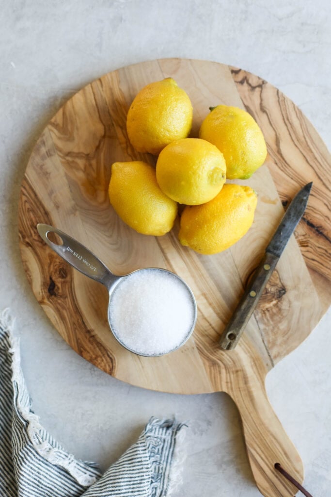 Lemons on a cutting board about to be prepped with salt.