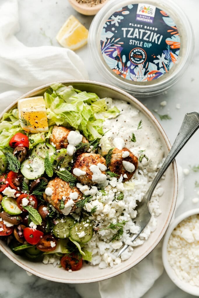 Overhead view Greek bowl topped with chicken meatballs and tzatziki sauce in stone bowl