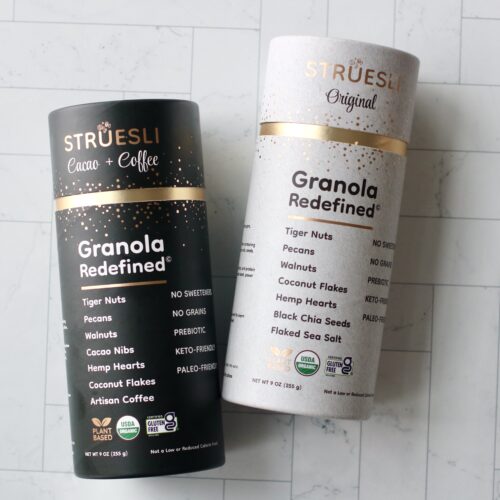 Two containers of Struesli, a grain-free granola brand, against white tiled background