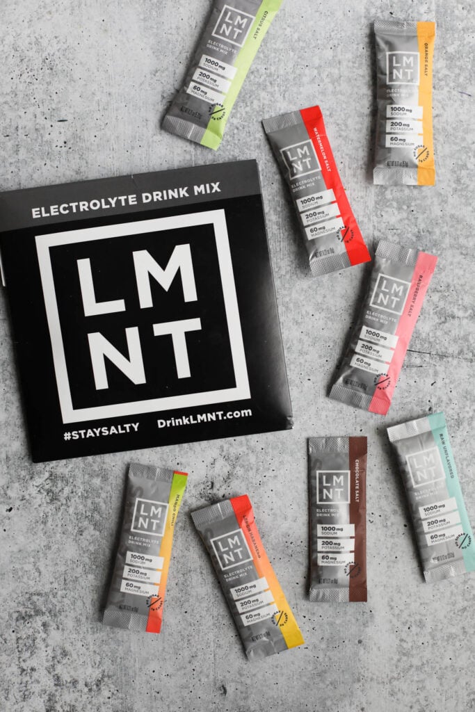 Various flavors of individual LMNT Electrolyte Drink Mix sticks, including Chili Mango, Lemon Habanero, Raw Unflavored, Chocolate Salt, Raspberry Salt, Citrus Salt, Watermelon Salt, and Orange Salt. 