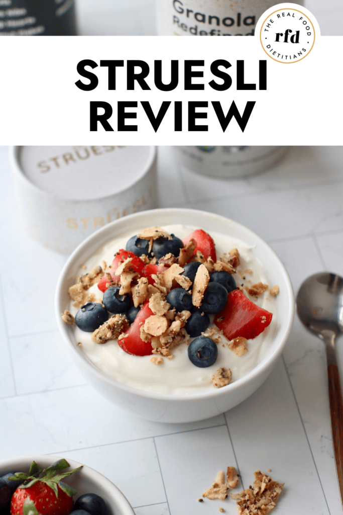 White bowl with serving of yogurt topped with fresh berries and Struesli grain-free granola