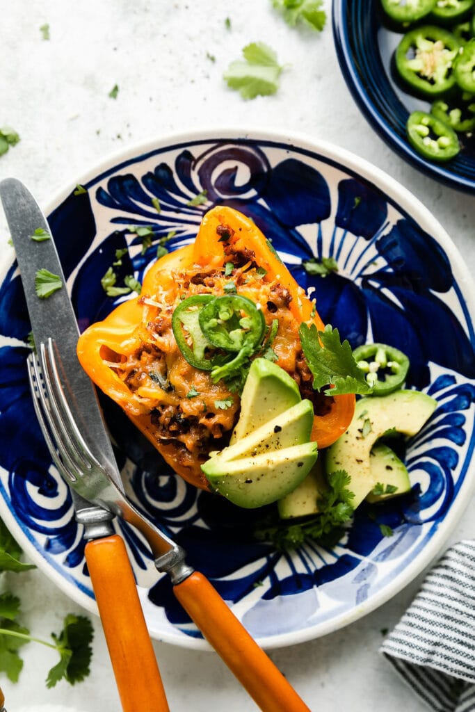 A plated taco stuffed pepper topped with jalapeno, avocado, and cilantro.