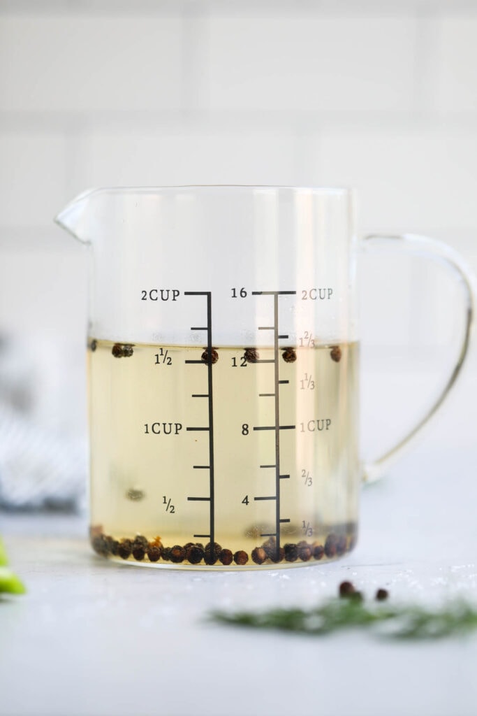  A measuring cup of pickle brine made with vinegar, salt, and a small amount of sugar.