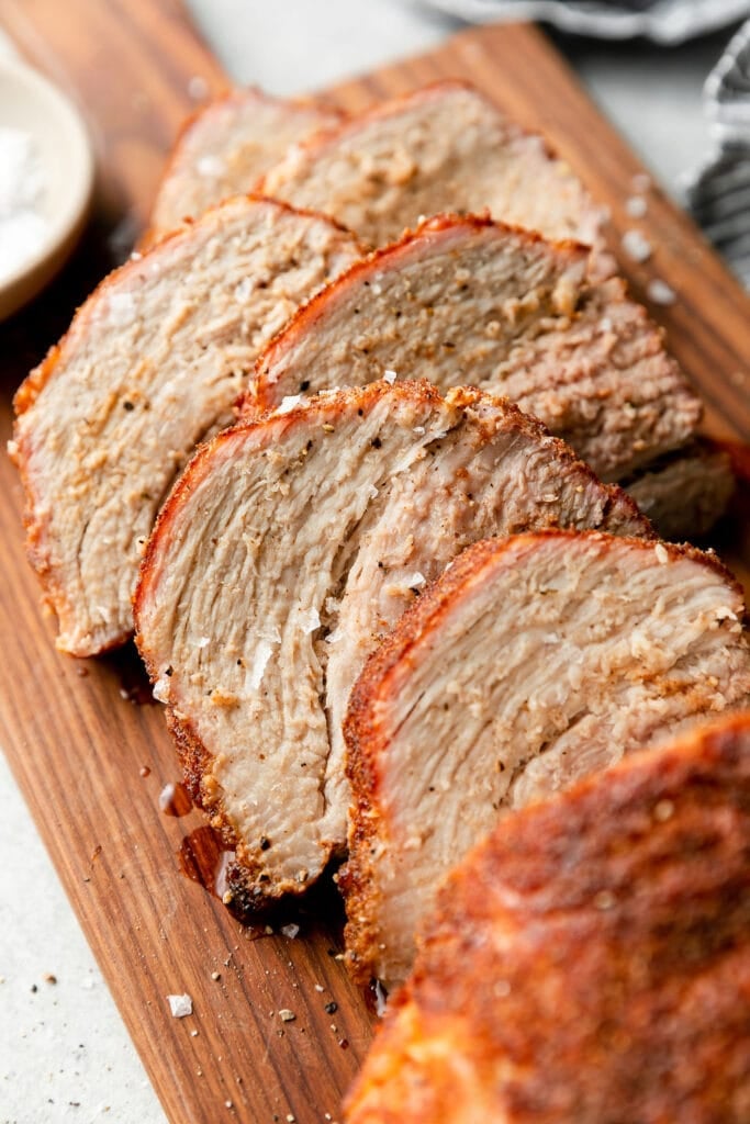 Close up view grilled pork loin cut into thick slices seasoned with rub