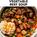 Overhead view serving Instant Pot Vegetable Beef Soup in stone bowl with cheddar biscuit on top