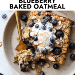 Serving of blueberry baked oatmeal on plate topped with yogurt and fresh blueberries