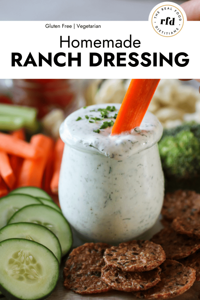 Small jar filled with homemade ranch dressing, a carrot stick dipping into ranch.