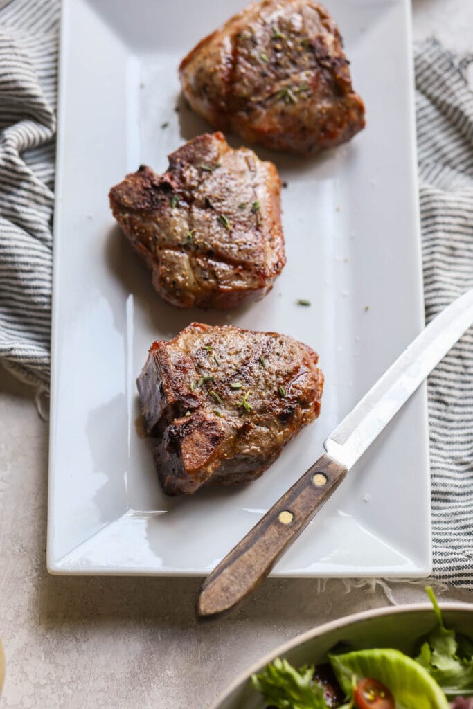 Grilled lamb chops on white platter