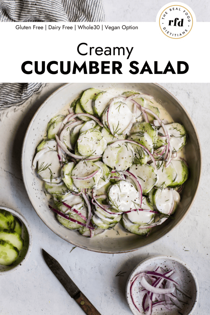 Overhead view shallow stone bowl filled with creamy cucumber salad with red onion and fresh dill