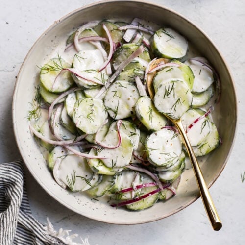 Overhead view shallow stone bowl filled with creamy cucumber salad