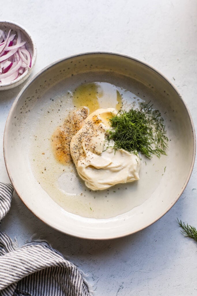 Dressing ingredients in stone shallow bowl for creamy cucumber salad