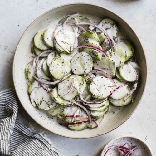 Overhead view stone serving bowl filled with creamy cucumber salad