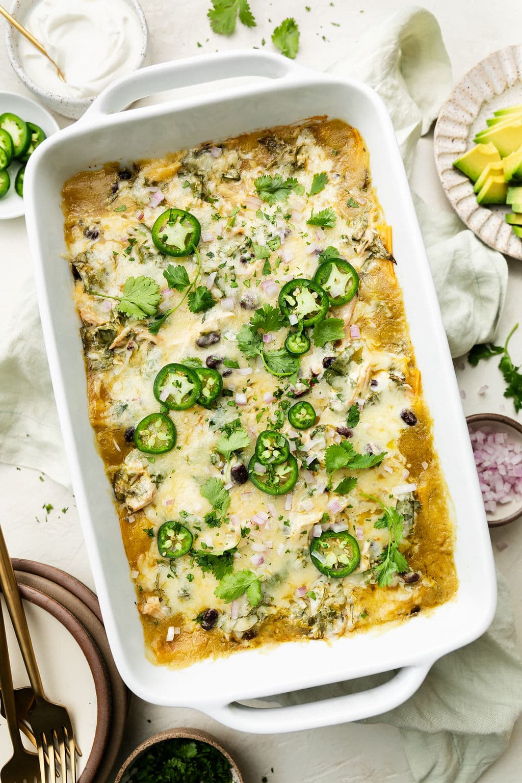 Overhead view green chicken enchilada casserole in white baking dish