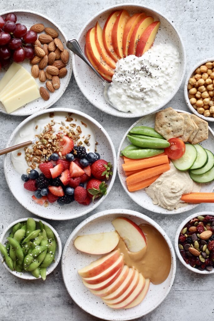 Overhead view several shallow bowls with snack options