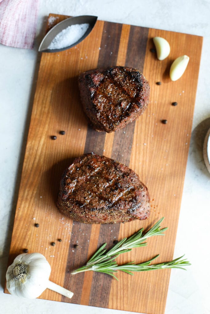 Grilled grass fed beef steaks on cutting board