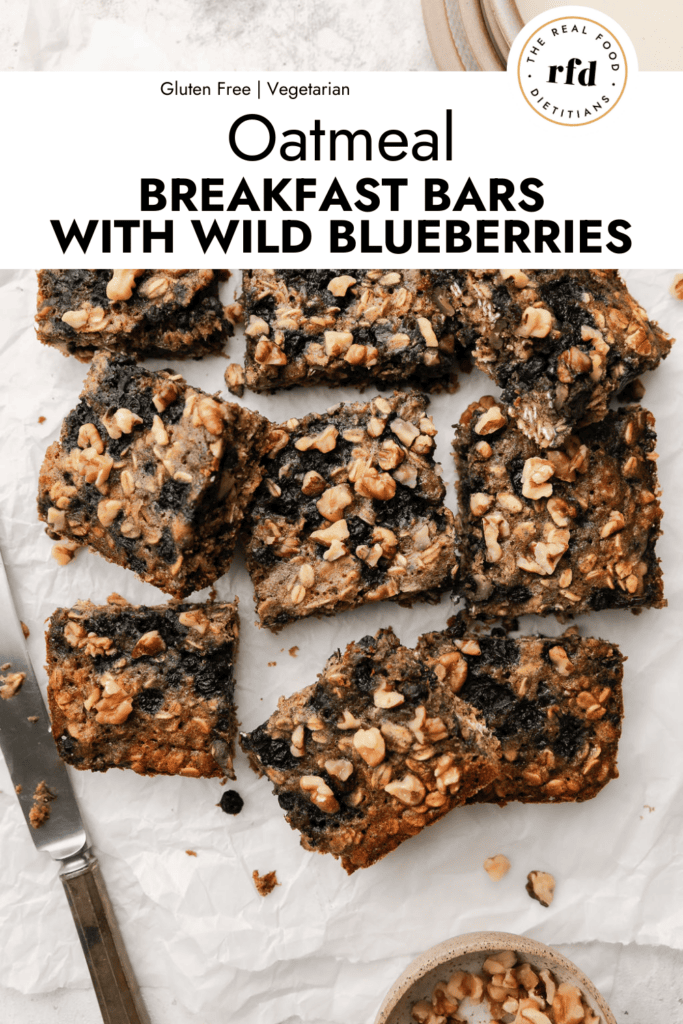 Batch of oatmeal breakfast bars with wild blueberries cut into squares on parchment paper