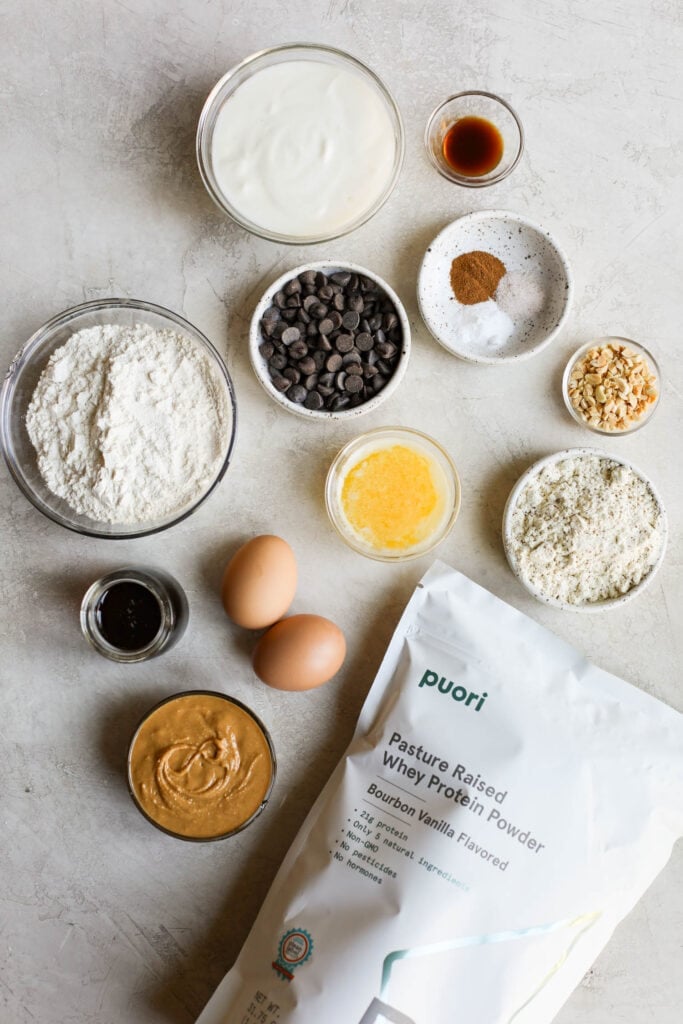 Overhead view all ingredients for protein muffins arranged together in small bowls.